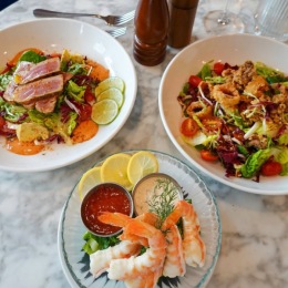 Boiled shrimp and food salads on a table